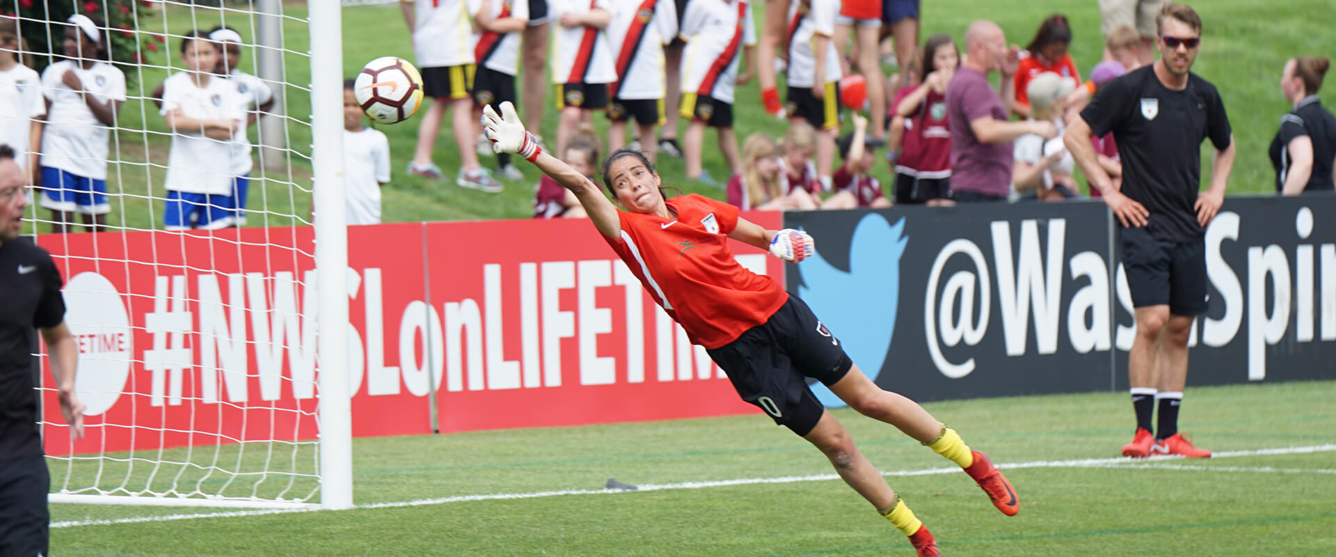 Football goalkeeper diving to stop the ball.