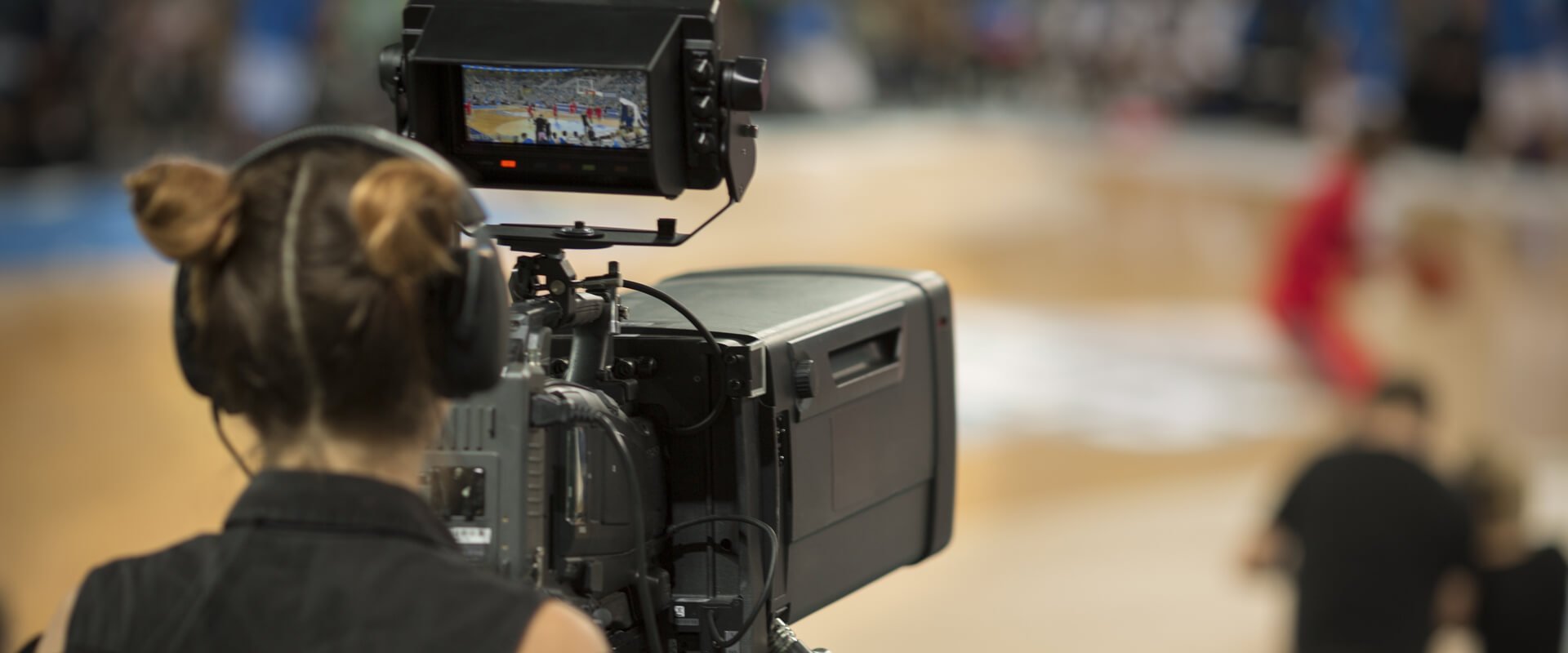 Camera operator capturing a basketball game.